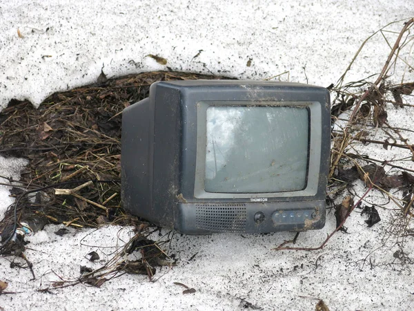 discarded equipment - an old monitor is lying on the street in the spring