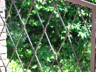 Yazın nehrin üzerinde dövülmüş demir kafesli eski bir köprü.