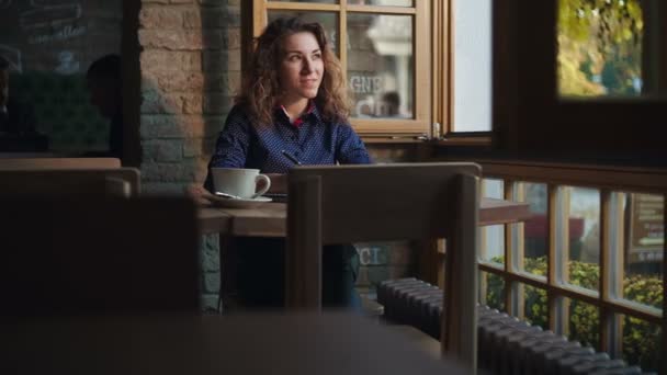 Girl in cafe writing in notepad — Stock Video