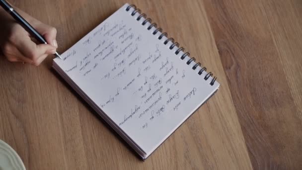 Hände zeichnen in Notizbuch auf Betttisch — Stockvideo