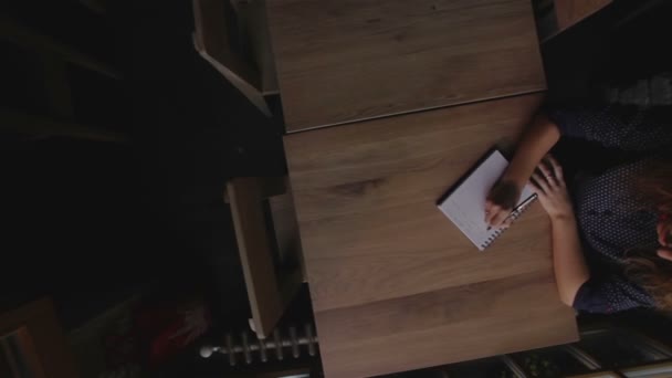 Chica escribiendo en el cuaderno en la cafetería — Vídeos de Stock