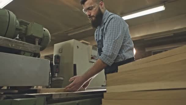 Carpintero trabajando con herramienta industrial en fábrica de madera. Grabación de vídeo RAW . — Vídeo de stock