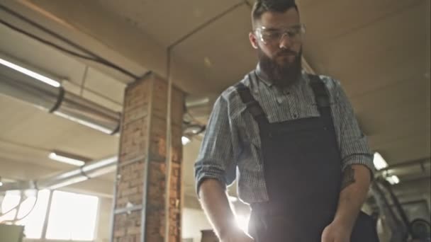 A fiatal szakállas munkás fa gyárban. Nyers videofelvétel. — Stock videók