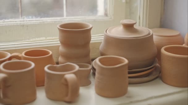 Cerámica, tazas y otros productos en los sills de cerámica antigua. Grabación de vídeo RAW . — Vídeo de stock