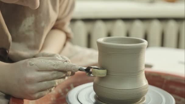 Mladý potter klade vzorek na hliněné vázy. Surový video záznam. — Stock video