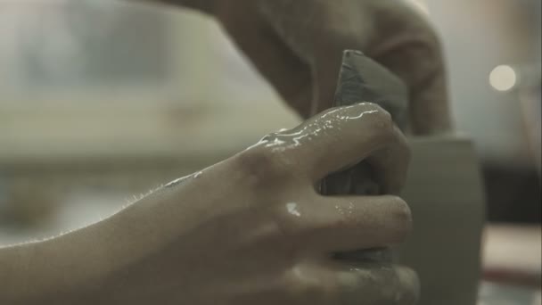 Close-up van potter draaien een pot op een potter. Ruwe videoverslag. — Stockvideo