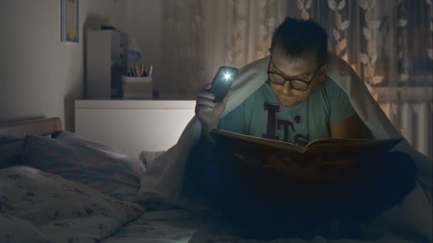 Hombre adulto gafas divertidas libro de lectura. Un joven leyendo libros en casa. Grabación de vídeo RAW . — Vídeo de stock