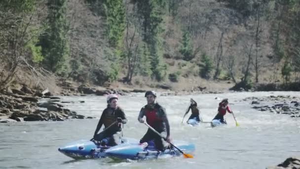 Los kayaks gobernados por el equipo mixto del hombre y la mujer antes de la carrera a partir de — Vídeo de stock