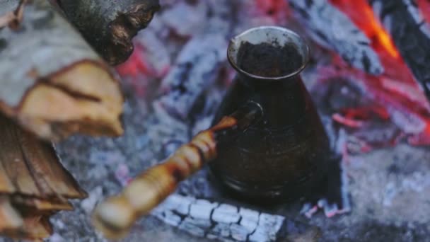 Turk koffie pot op brandhout cools in reizen voorwaarden. — Stockvideo