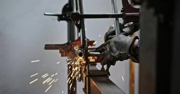 De lasser in de werkplaats vervaardigt en verbindt metalen constructies, de werknemer in het beschermend masker voert laswerkzaamheden uit in de werkplaats voor toekomstige teelt — Stockvideo