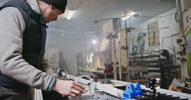 Master vyrábí nebo konfiguruje CO2 laser ve výrobě garáží. Vlastní podnikání pro výrobu dílů na laseru na bázi oxidu uhličitého. — Stock video