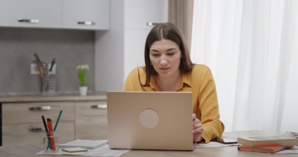 Jonge vrouw die thuis werkt op een laptop ontvangt een gelukkig sms goed nieuws verheugt zich kan niet geloven dat haar ogen schreeuwt van geluk — Stockvideo