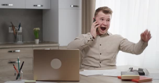 Excited freelancer listening to good news on smartphone — Stock Video