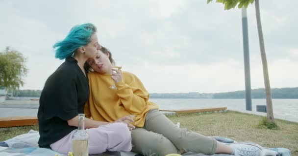 Houden van jonge vrouwen in een gay relatie vieren aan de kust genieten van een glas witte wijn als ze knuffelen dicht bij elkaar in een teder moment — Stockvideo