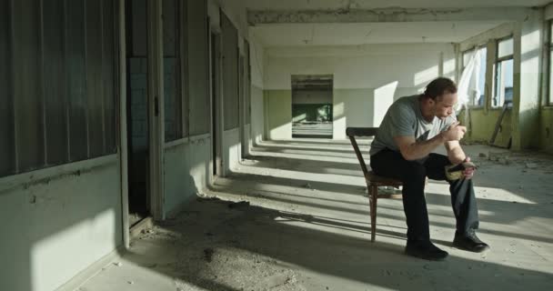 放棄された建物の中で喫煙悲しい男 — ストック動画