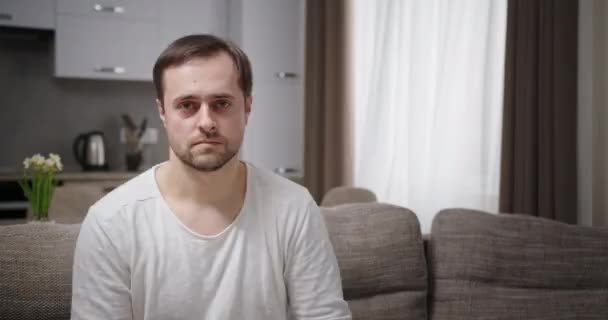 Fröhlicher erwachsener Mann auf Sofa zeigt weg — Stockvideo