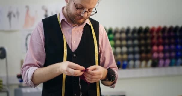 Close up przycięty widok krawca pracującego na odzieży w swoim warsztacie lub studio, jak produkuje ubrania na zamówienie — Wideo stockowe