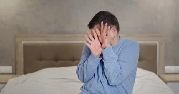 Disgusted mature man covering face on bed — Stock Video