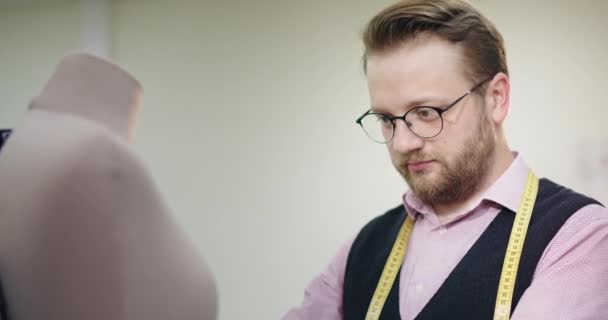 Designer dengan kacamata dan janggut menjahit gaun di manekin — Stok Video