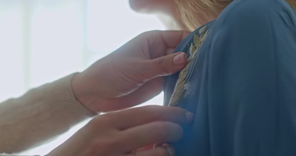 Adapter une belle robe en lin avec un concepteur d'épillets brodé à la main corrige les détails sur le modèle dans son atelier — Video