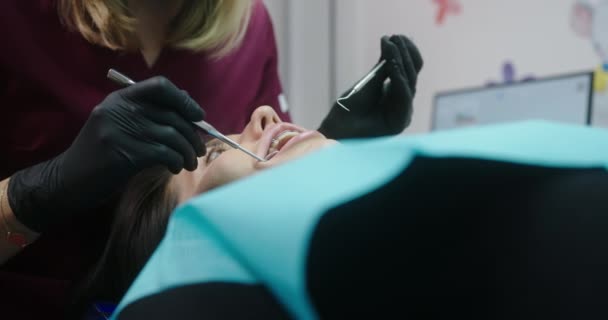 Tandheelkundige behandeling proces onderzoek van beugels vrouwelijke patiënt liggend met mond open in tandheelkundige kliniek vertrouwen in tandarts vrouwelijke orthodontist — Stockvideo