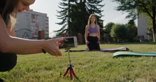 Спортсменки начинают онлайн тренировку в парке — стоковое видео