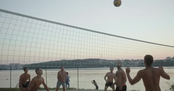 Hombres sin camisa jugando voleibol cerca del río — Vídeo de stock
