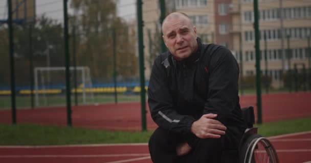 Bezbariérový sportovec sedící na invalidním vozíku u sportovního hřiště — Stock video