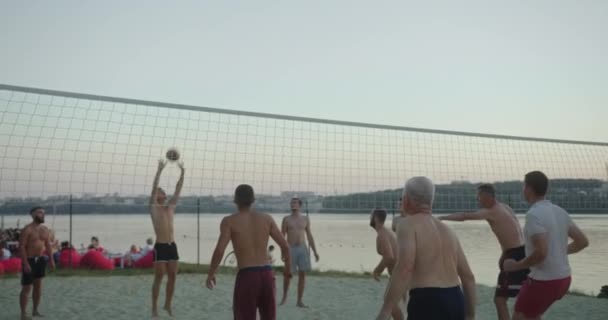 Männergruppe spielt Beachvolleyball — Stockvideo