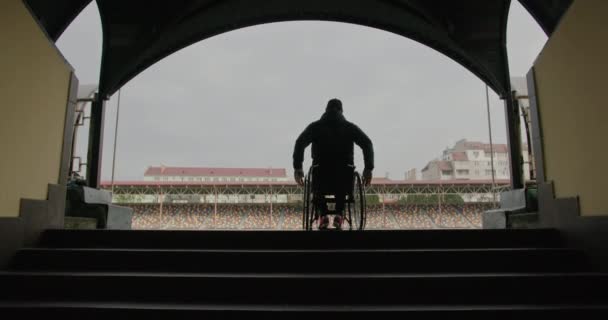 Stadyumda tekerlekli sandalyede tanınmayan bir sporcu. — Stok video