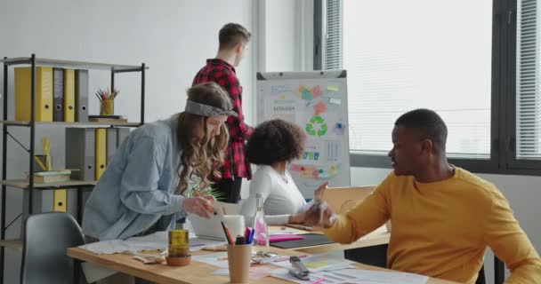 Team multirazziale di giovani bianchi e afro lavoro di squadra in ufficio sul computer portatile positivo sull'ecologia — Video Stock