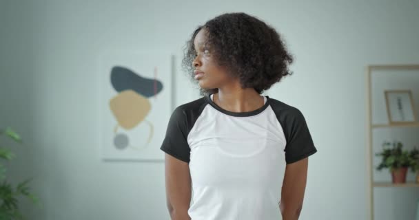 Güzel, koyu tenli, Afro-Amerikalı kıvırcık saçlı ve kameraya endişeyle bakan bir kız. — Stok video