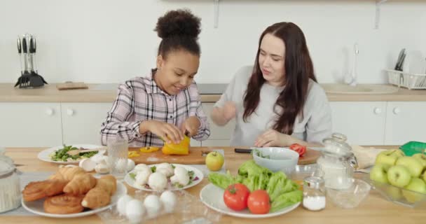 Η μαμά και η κόρη μαγειρεύουν Πολυφυλετική οικογένεια λευκή μαμά και αφροαμερικάνικο κορίτσι μωρό φιλικό θετικά μαζί μαγείρεμα δίνοντας πέντε στο σπίτι στην κουζίνα — Αρχείο Βίντεο
