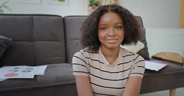 Happy black student sitting near sofa — Stock Video