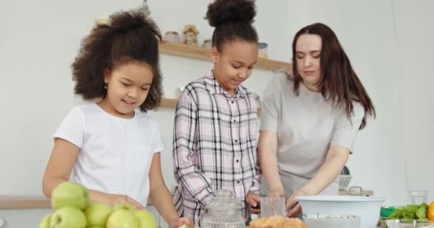 Mutter und Töchter verschiedener Rassen bereiten gemeinsam Essen zu — Stockvideo