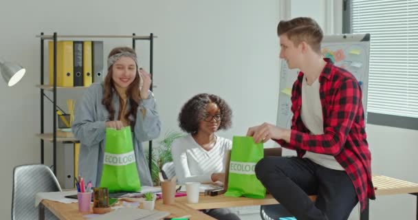 Multiracial kollegor med eco bags prata och använda bärbar dator — Stockvideo