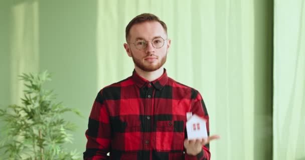 Hombre feliz mostrando casa de juguete y llaves — Vídeos de Stock