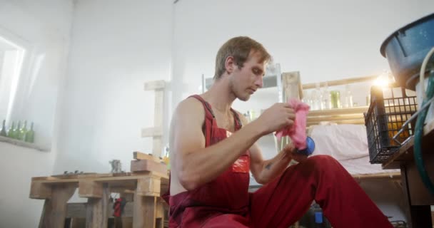 Řemeslník utírá polovinu modré láhve — Stock video