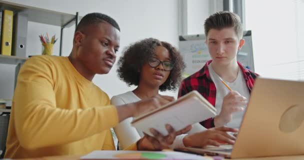 Diversi studenti con laptop che lavorano insieme al progetto di ecologia — Video Stock