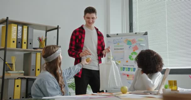 Grupo de estudiantes con bolsa ecológica trabajando en proyecto ambiental — Vídeos de Stock