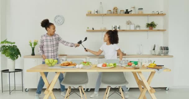 Černošky hrají v kuchyni během přípravy oběda — Stock video