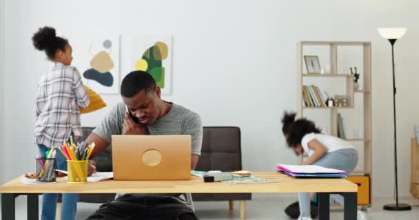 Afro-americano pai trabalhando perto de jogar filhas — Vídeo de Stock