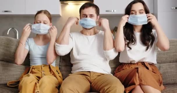 Familia poniéndose máscaras en casa - covid 19 concepto — Vídeos de Stock