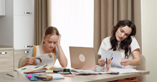 Mother working near studying daughter at home — Stock Video