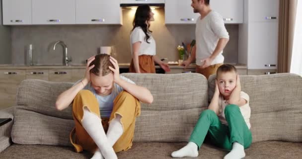 Streit Mama und Papa Eltern streiten schreiende Hysteriker winken Hände zu Hause. Streit mit Kindern, Kinder sitzen unglücklich verängstigt auf der Couch und verdecken ihre Ohren mit den Händen — Stockvideo