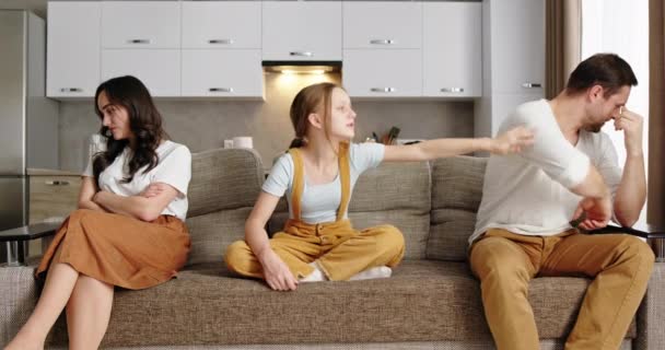 Kłótliwi rodzice siedzą w gniewie na siebie i nie zwracają uwagi na córkę, która siedzi zdenerwowana na Dianę między rodzicami, biedni rodzice kłócą się z dziećmi. — Wideo stockowe