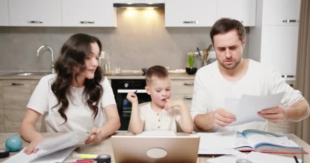 Problèmes dans la querelle familiale entre les parents fils assis à regarder cette peur. querelle assis à la maison à la table et ordinateur portable jetant des papiers — Video