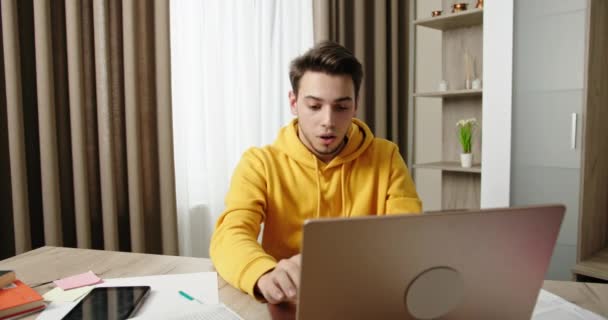 Посылает важное сообщение скрещивает пальцы и очень надеется, что молодой парень работает в домашнем офисе сидя за столом, работая на ноутбуке фрилансер — стоковое видео