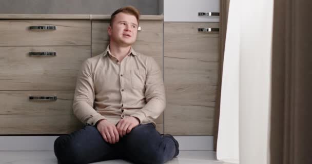 A man in despair sitting on his knees in the apartment at night frustrated screaming in despair a lonely emotional breakdown of the problem of divorce crisis — Stock Video