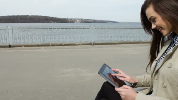 Jeune femme avec tablette sur le banc — Video